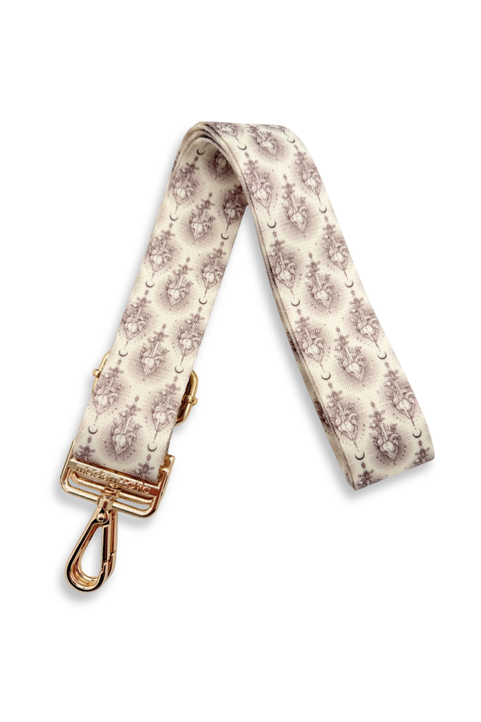 Patterned sword strap with gold hardware on a white background