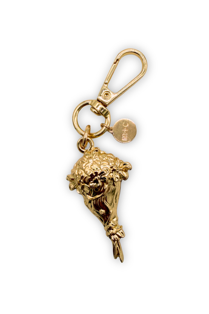 Gold keychain with a bouquet of blooms on a white background