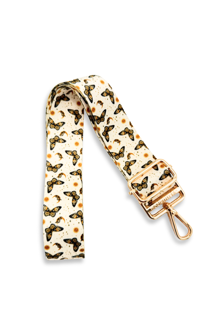Butterfly patterned strap with gold accents on a white background