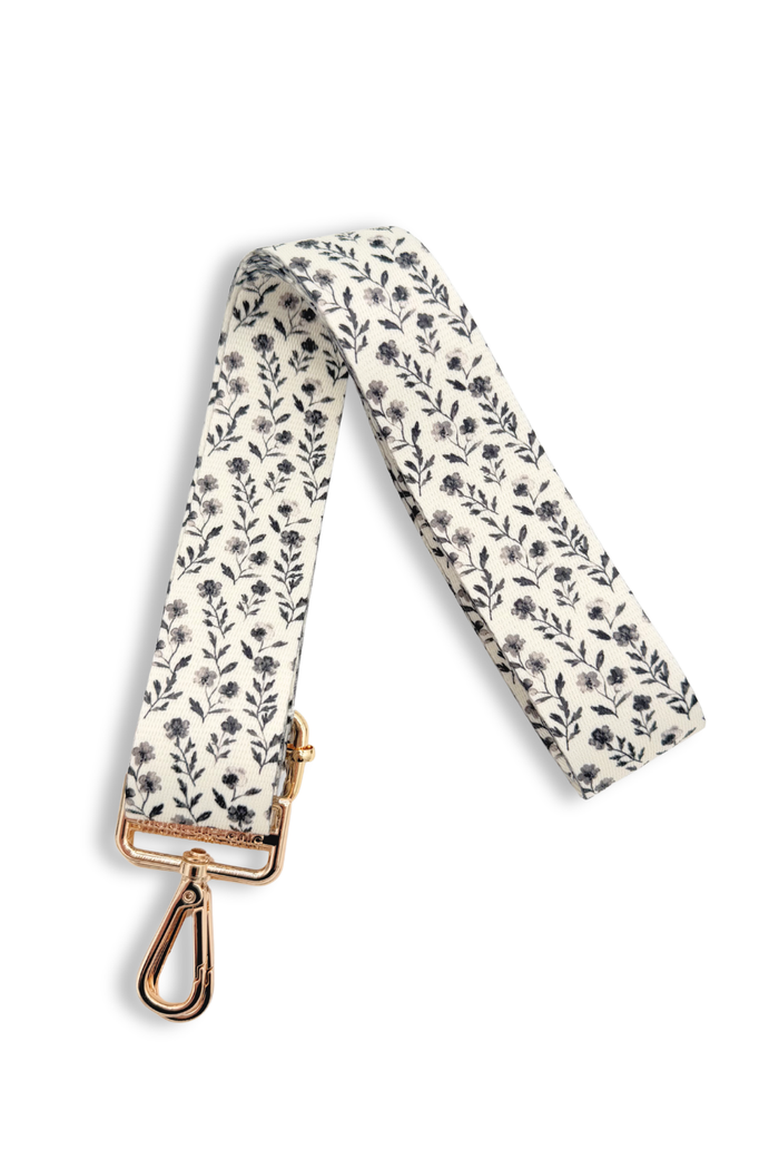 Black and white, floral-patterned strap with a gold clasp on a white background.