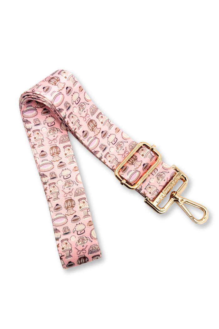 Pink teapot bag strap with gold buckle and pink pattern on a white background