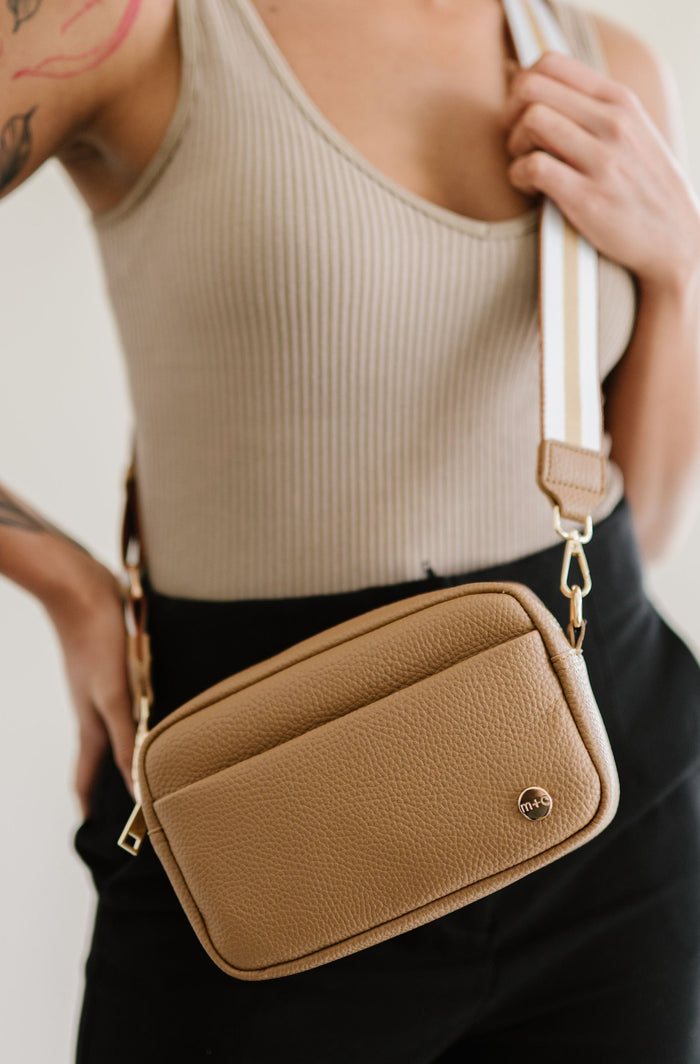 Woman wearing a beige Modern+Chic Willow Vegan Leather Convertible Crossbody Bag on a white background.